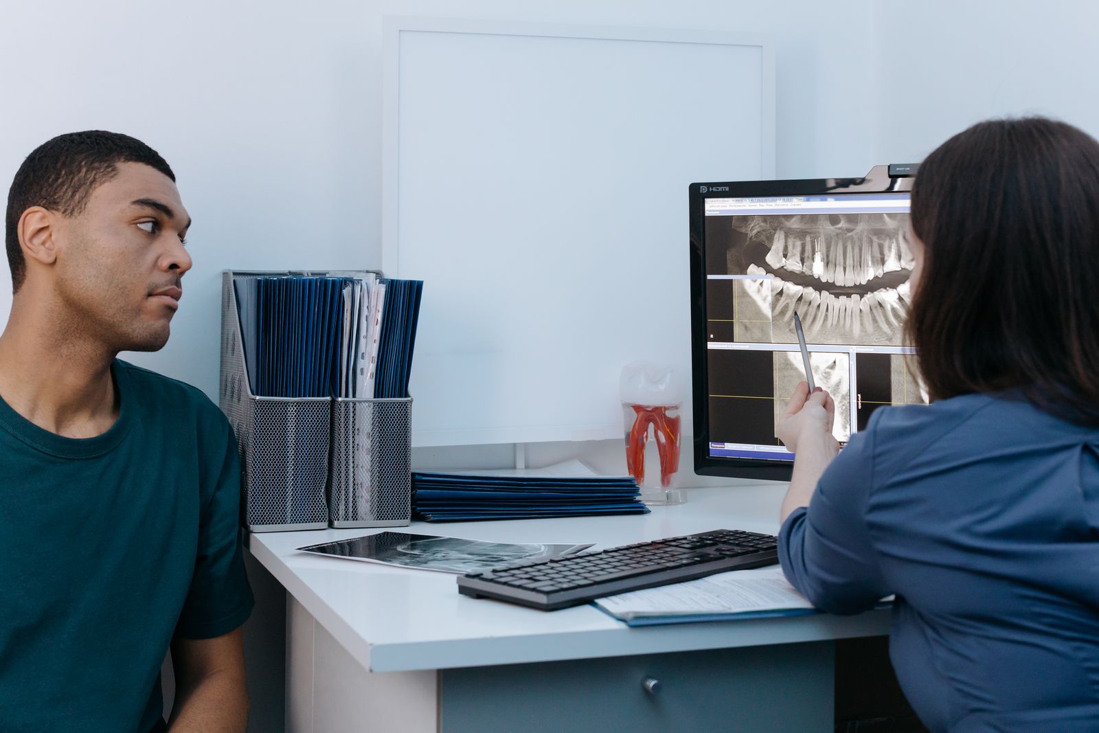Dentist discussing a dental X-ray with a patient during a consultation